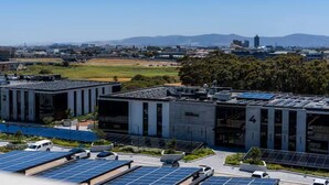 A modern building with solar panels, numbered sections, and a parking area. - Golden Nectar (Cape Town)