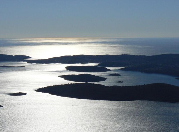 A coastal landscape with calm waters and several islands.