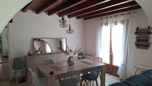 Ein Essbereich mit Holztisch, Stühlen und Pendelleuchten.