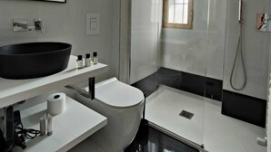 A modern bathroom with a large black sink, a toilet, a bidet, and a glass-enclosed shower. - The Rabbit Hole: Unique Design Stay in Milan Downtown with AC and Wifi (Milano)