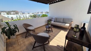 A balcony with wicker chairs, a small table, a sofa, and a potted plant. - Family retreat: Relaxation and disconnection (Yautepec)