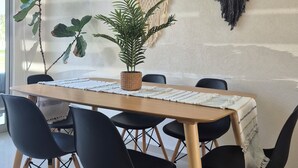 A dining area with a wooden table, black chairs, a potted plant, and two wall hangings. - Family retreat: Relaxation and disconnection (Yautepec)