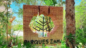 Une enseigne ornée d’un motif tissé et de la silhouette d’un arbre, sur laquelle on peut lire : « DR QUOTES ZAM ».