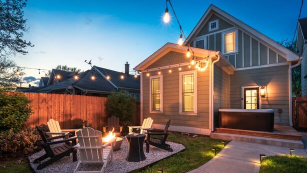 A backyard with a fire pit, outdoor seating, and a hot tub. - Pregame Palace | Hot Tub • HGTV • Garage Parking • Pets (Indianapolis)