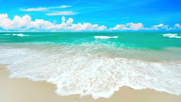 A beach with waves, a clear sky, and clouds. - Anna Maria Island -walk to the beach, shops and restaurants! (holmes Beach)
