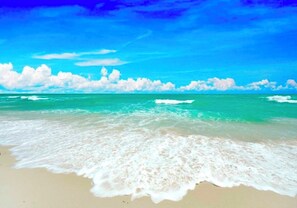 A beach with waves, a clear sky, and clouds. - Anna Maria Island -walk to the beach, shops and restaurants! (holmes Beach)