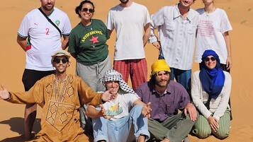A group of people posing in a desert setting.