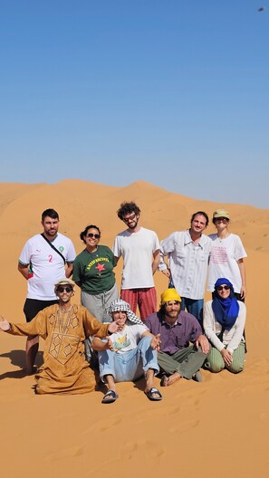 A group of people posing in a desert setting.
