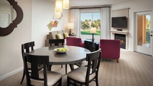 A hotel room with a dining table, chairs, a sofa, a TV, a fireplace, and a view of a golf course. - April 12-16th - FLASH SALE - Marriott Shadow Ridge - Full Access Resort (Palm Desert)