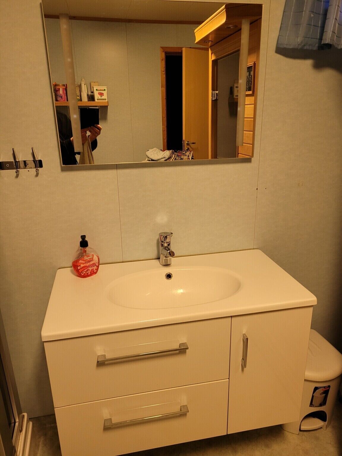 Ein Badezimmer mit Waschbecken, Spiegel und Toilette.