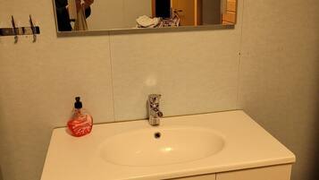 Ein Badezimmer mit Waschbecken, Spiegel und Toilette.