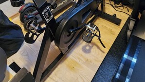 A stationary bike with a digital display, a wall-mounted TV, and posters of football players. - Studio with fitness room (Troms)