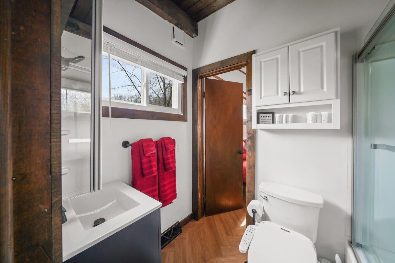 A bathroom with a white sink, a toilet, and a shower area.