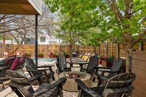 An outdoor patio with a fire pit, seating area, and a swimming pool. - Rainey Hideaway | Pool | Hot tub| BBQ | DT ATX (Austin)