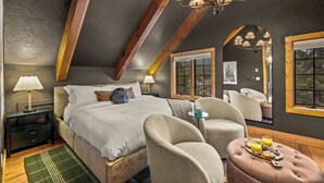 A bedroom with a bed, bedside tables, a lamp, a mirror, and a breakfast tray.