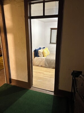 Ein Zimmer mit Bett, Fenster und Tür.