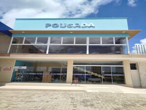 Un edificio de dos pisos con un letrero que dice 'POUSADA' sobre la entrada.