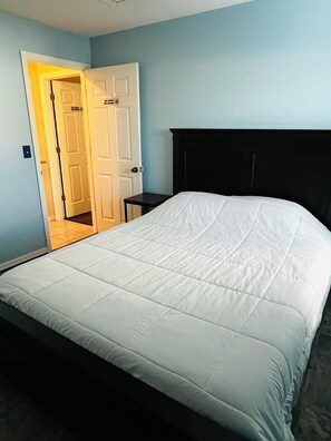 Une chambre à coucher avec un lit, une porte et une petite table.