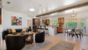 A spacious living area with a sofa, armchairs, and a dining table. - NEW Steps to the Sand on Mesa Lane 3 BD 2BA with Jacuzzi! (Santa Barbara)