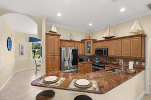 Una cocina con armarios de madera, electrodomésticos de acero inoxidable y encimera de granito.