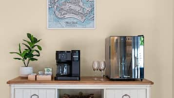 Eine Küchenzeile mit Kaffeemaschine, zwei Gläsern und einer Karte an der Wand.