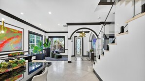Een modern interieur met een eethoek, een trap en uitzicht naar buiten.