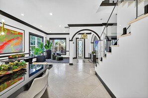 Un intérieur moderne comprenant un coin repas, un escalier et une vue sur l’extérieur.