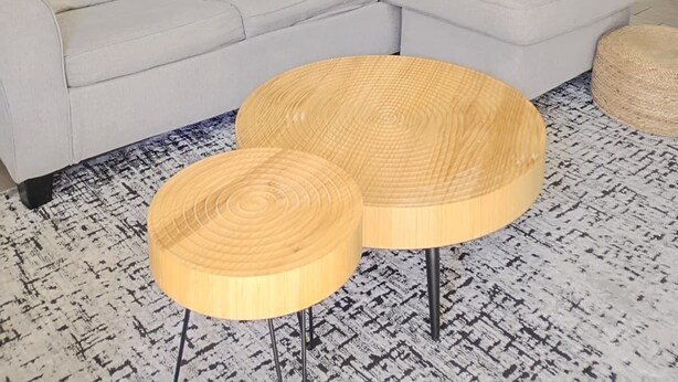 Una sala de estar moderna con un sofá seccional, mesas de centro redondas de madera y un cuadro abstracto grande en la pared.