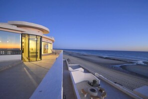 Ein modernes Gebäude mit Glasfassade mit Blick auf einen Strand.