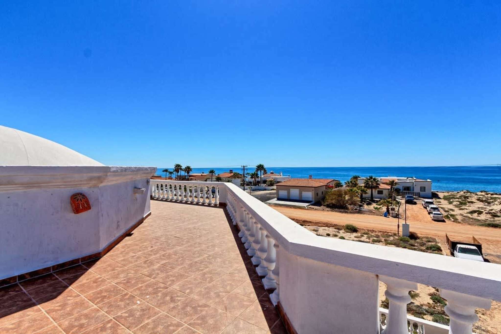 Un balcón con vista a la playa y al océano.
