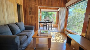 A modern living room with a grey sofa, a wooden coffee table, and a wooden cabinet. - Sandmo Holiday Home 11 (Ålands landsbygd)
