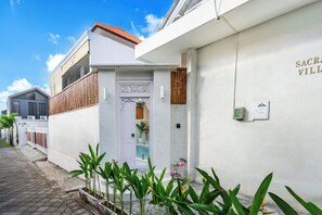 A white building with a sign reading 'SACRAVILLE' and a door with a decorative design. - Sacral Luxury Villa with a private pool (Canggu)