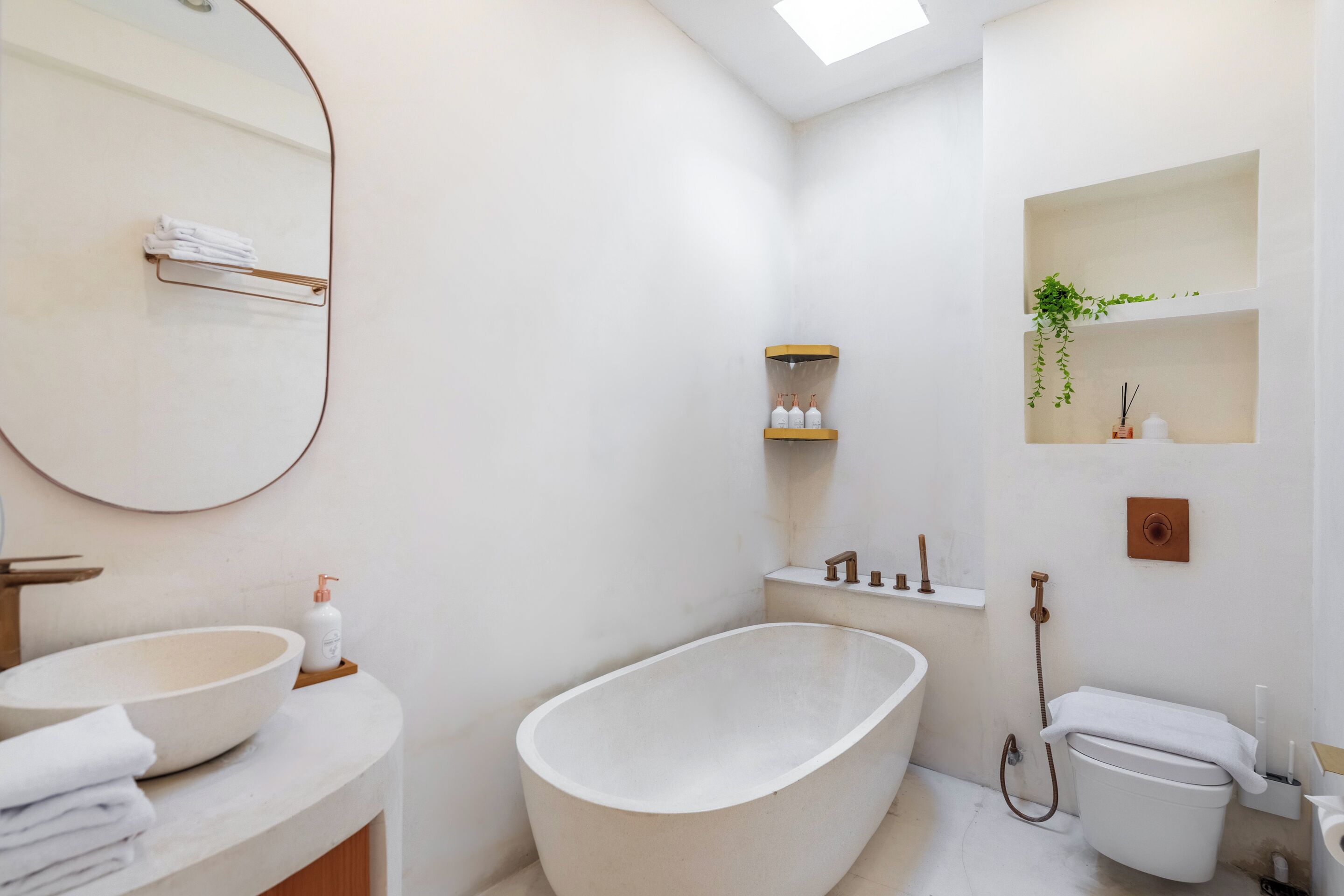 A modern bathroom with a freestanding bathtub, a large mirror, and a sink with a bowl basin.