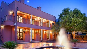 A two-story building with a balcony, a fountain, and a tree in the foreground. - Bluegreen's Lodge Alley Inn: Historic Charm, Modern Comfort, Top Location-Studio (Charleston)