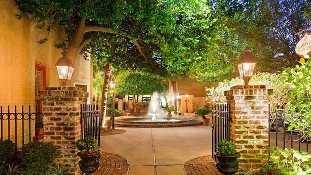 A courtyard with a fountain, stone walls, and potted plants. - Bluegreen's Lodge Alley Inn: Historic Charm, Modern Comfort, Top Location-Studio (Charleston)