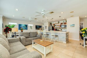 A spacious living area with a sofa set, a wooden coffee table, and a kitchen area with a bar. - Lookout & Paradise - 2 Units On the Beach! (Surfside Beach)