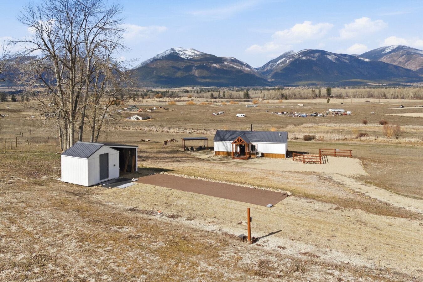 Una propiedad rural con un cobertizo pequeño, una estructura de madera y un área cercada.