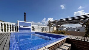 A rooftop pool with blue tiles, wooden deck, and a pergola. - Casa Sisiguaca by Xarm Apartments (Santa Marta)