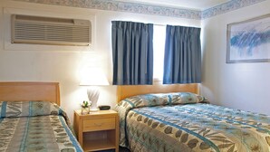 Een slaapkamer met twee bedden, een nachtkastje met een lamp, een raam met gordijnen en een airconditioning.