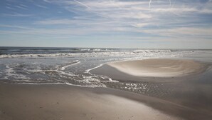 A beach with sand, waves, and a clear sky. - Lotus Inn - Deluxe Poolside Efficiency Suite (Wildwood Crest)