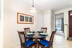 Een eethoek met een ronde tafel, vier stoelen en een hanglamp.