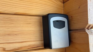 A corner of a wooden cabin with a black object, possibly a device, mounted on the wall. - Cozy 1-bedroom cabin perfect for 2 in Willemstad (Willemstad)