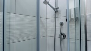 A shower with a handheld showerhead and a wall-mounted control panel. - Deluxe Double Room 102 (Catania)