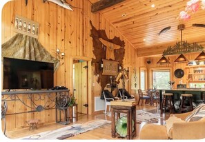 Ein Holzinterieur mit Kamin, Bar und Sitzgelegenheiten.
