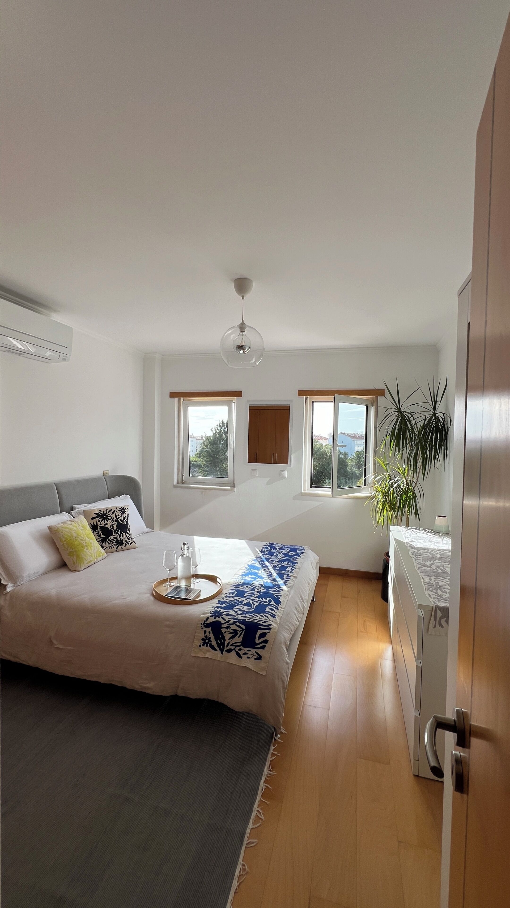 A bedroom with a bed, bedside table, and a window.