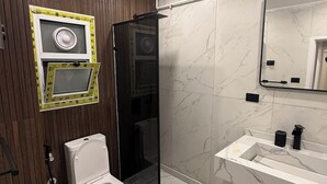 Un baño moderno con inodoro, ducha y lavamanos.