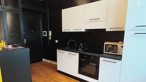 Una cocina moderna con armarios blancos, un microondas y una estufa.