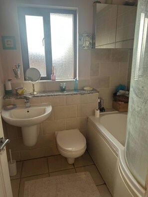 A bathroom with a sink, toilet, and bathtub. - Cosy Family Home With Full Amenities (Uxbridge)