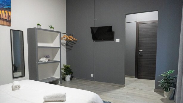 Une chambre d’hôtel moderne équipée d’un lit, d’une armoire, d’une télévision et d’une porte.