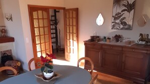 Ein Essbereich mit Tisch, Stühlen und einer Küche im Hintergrund.